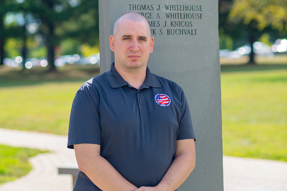 Army veteran in front of memorial